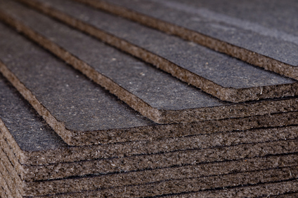 Flera lager av mörkgrå, rektangulära asfaboardplattor staplade ovanpå varandra i en sned vinkel.