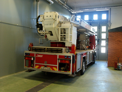 Brandbil med stege parkerad i en station. Registreringsnummer LNP 7704 synligt.