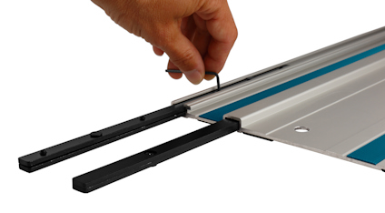 Hand justerar en skena med två svarta glidstänger och blå detalj.