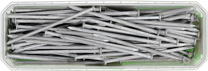 En rektangulär låda fylld med flera metallspikar.
