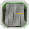 Staples neatly stacked in a green container secured with a yellow rubber band.