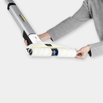 Hand som håller en färgroller med långt skaft, designad för att underlätta målning av väggar och tak.